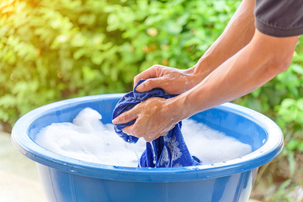 hand washing clothes in Blue basin